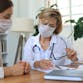 A woman doctor and a woman patient looking at documents at a desk.