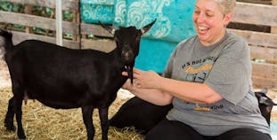 Julie Greenwood poses with a goat during a yoga fundraising event. 