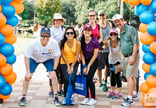 A group of people pose under balloons during a Team NPF event.