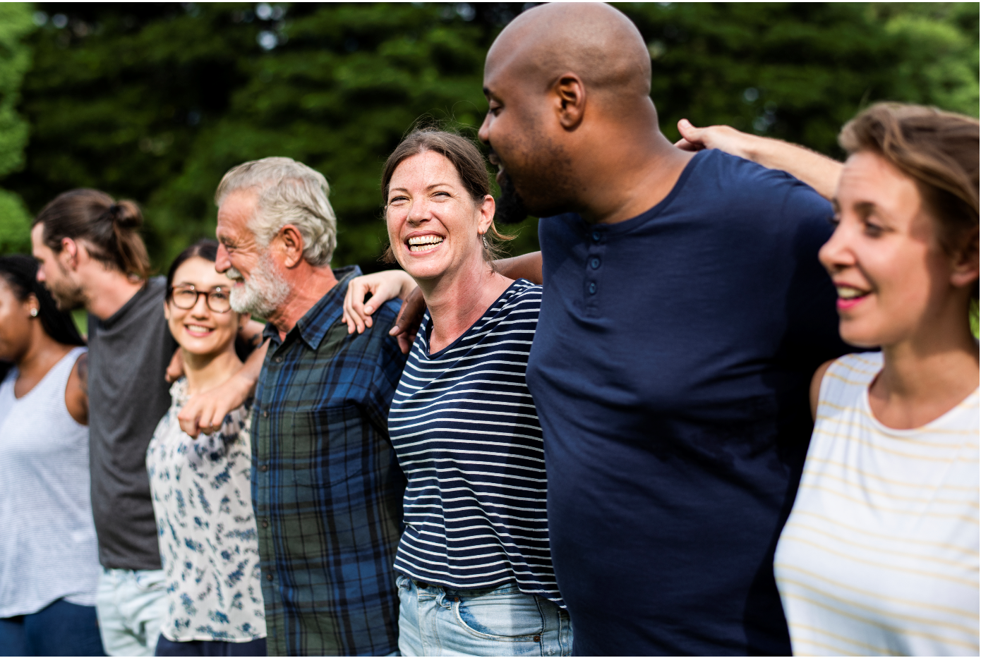 A group of adults embrace outside. 