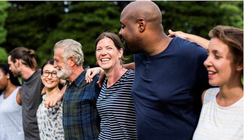 A group of adults embrace outside. 