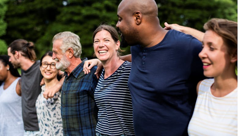 A group of adults embrace outside. 