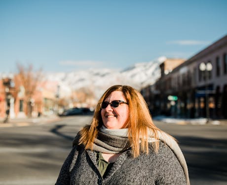 Lisa standing outside buildings.