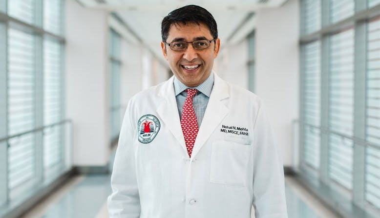 Researcher Nehal Mehta smiles while wearing his white coat.