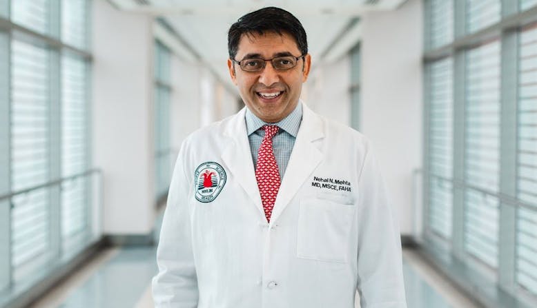 Researcher Nehal Mehta smiles while wearing his white coat.