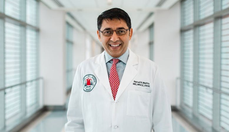 Researcher Nehal Mehta smiles while wearing his white coat.