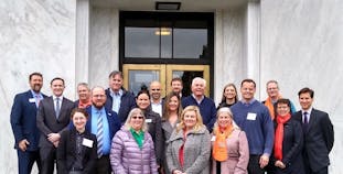 A group of advocates stand outside a government building.