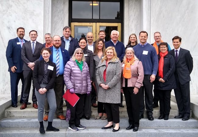 A group of advocates stand outside a government building.