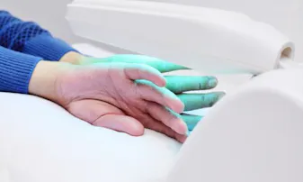 A pair of hands placed under a light medical device.
