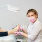 A podiatrist inspects a patient's foot in an exam room.