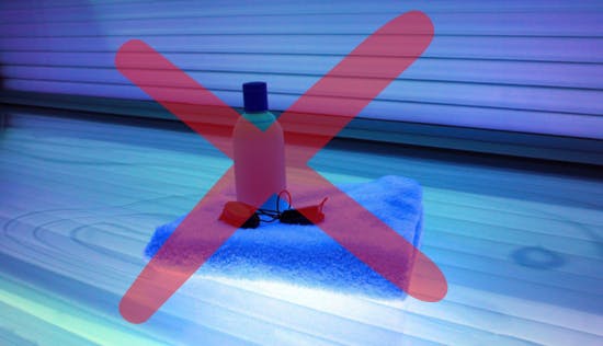A picture of a tanning bed, towel, glasses, and lotion with a red X overlaid.