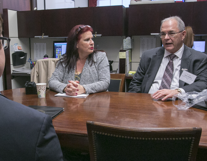 John Espers talks to others about his medical bills around a table. 
