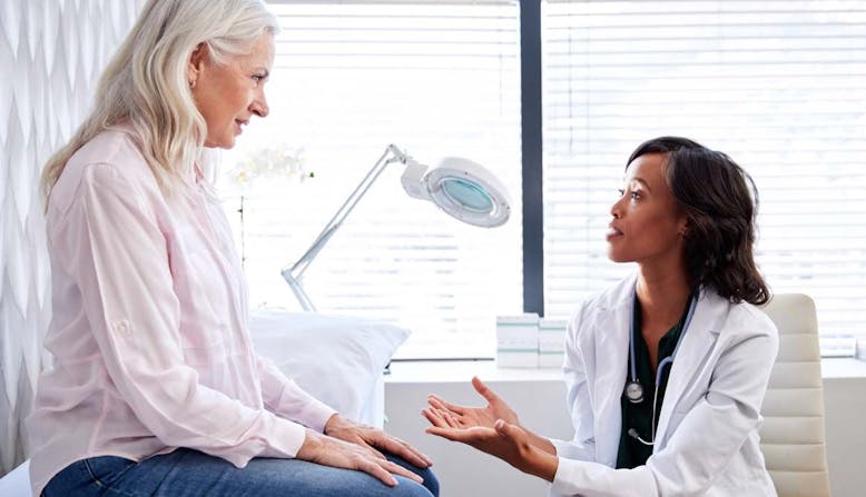 A woman talks to her doctor in an office.