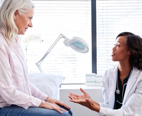 A woman talks to her doctor in an office.