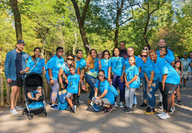 A group of NPF event participants wearing Plaque Busters t-shirts outside in a park.