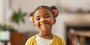 A child smiles at the camera.