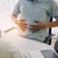 Man holding his stomach while talking to a doctor.