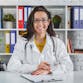 A female doctor sitting at a desk in a hospital.
