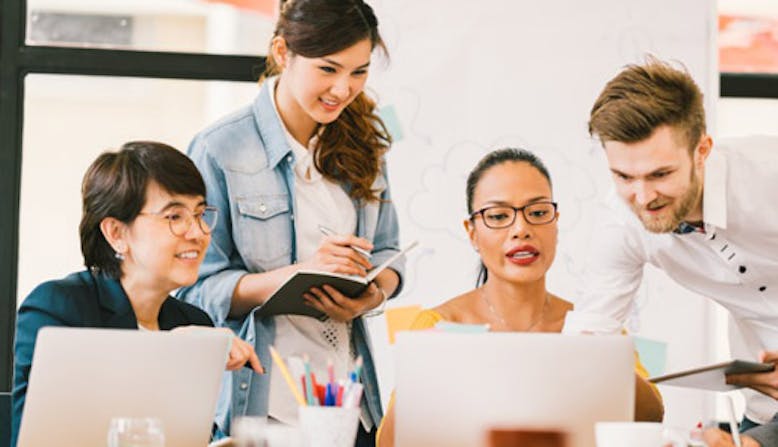 Group of people collaborating on a project in an office.