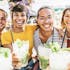 A multiracial group of friends smiling at the camera and toasting with their mojitos.