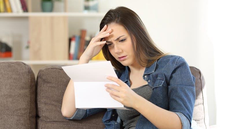 A woman looks confused while reading over her medical insurance plan.