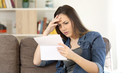 A woman looks confused while reading over her medical insurance plan. 