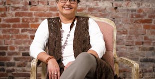 NPF volunteer Tami Seretti sits in a chair and smiles.