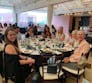 A group of people sitting at a large table playing bingo at a Pstamp Out Psoriatic Disease event.
