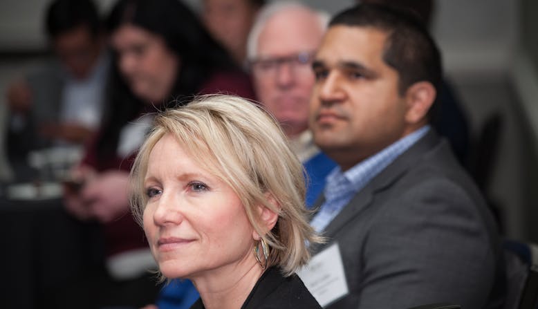 A woman sits with other participants as they listen to a training on advocacy.