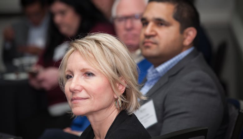 A woman sits with other participants as they listen to a training on advocacy.