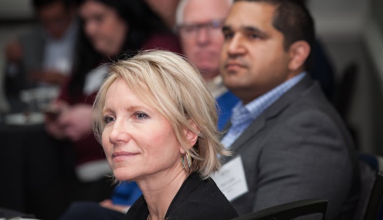 A woman sits with other participants as they listen to a training on advocacy.