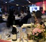 Evening event with flowers and wine bottles on the table.