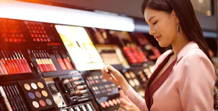 A woman looks at lip color in a cosmetic makeup store.