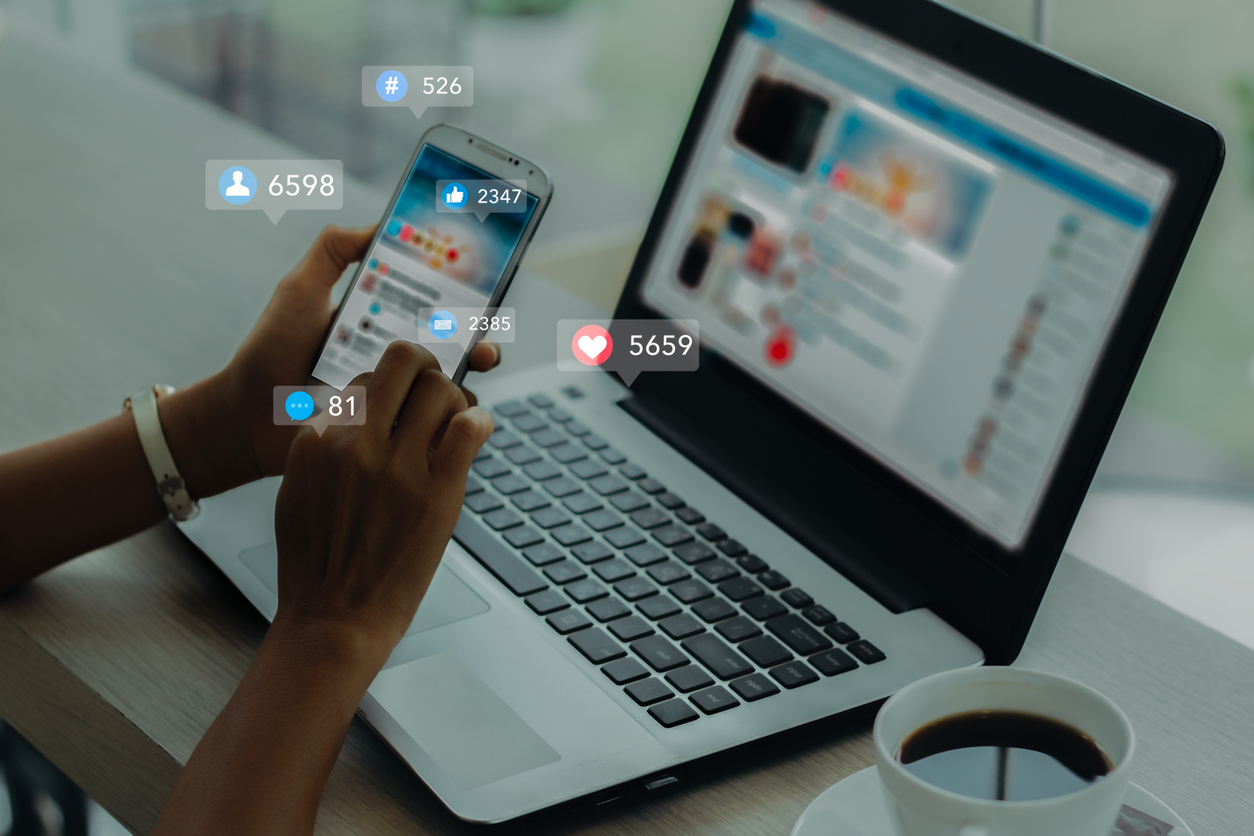 Social media open on a laptop and mobile phone.