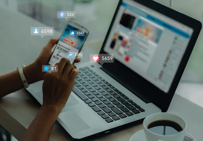 Social media open on a laptop and mobile phone.