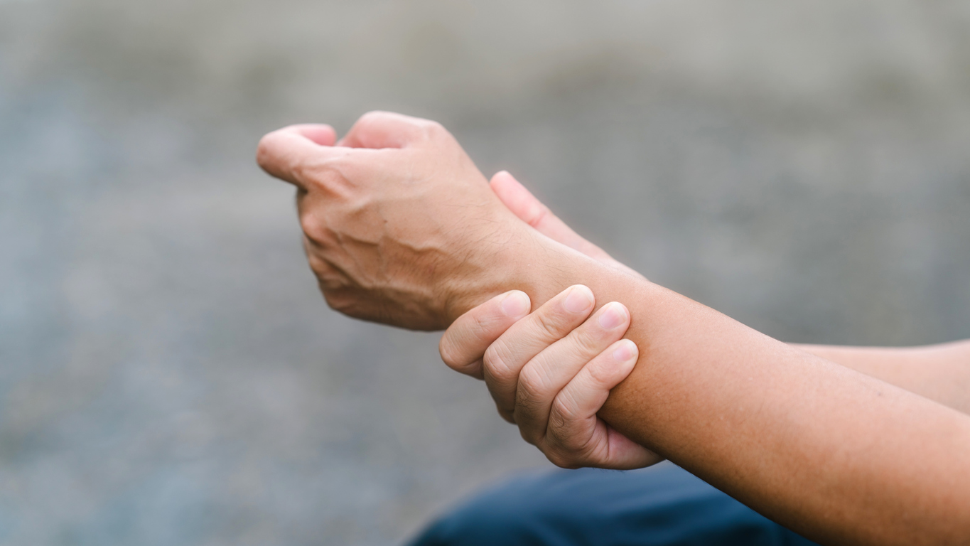 A person holding their wrist in pain.