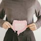 A woman from the shoulders down holds an illustration of the intestines over her stomach.