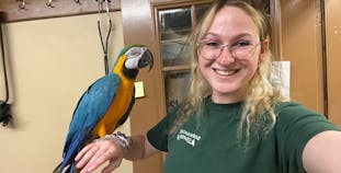 NPF Youth Ambassador Jackie Nachmias holding a parrot.