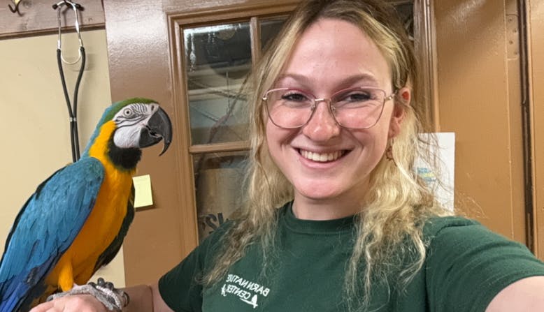 NPF Youth Ambassador Jackie Nachmias holding a parrot.