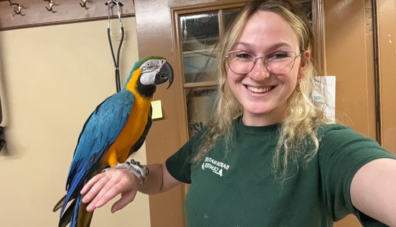 NPF Youth Ambassador Jackie Nachmias holding a parrot.