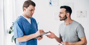 A male patient is talking to a male health care provider.