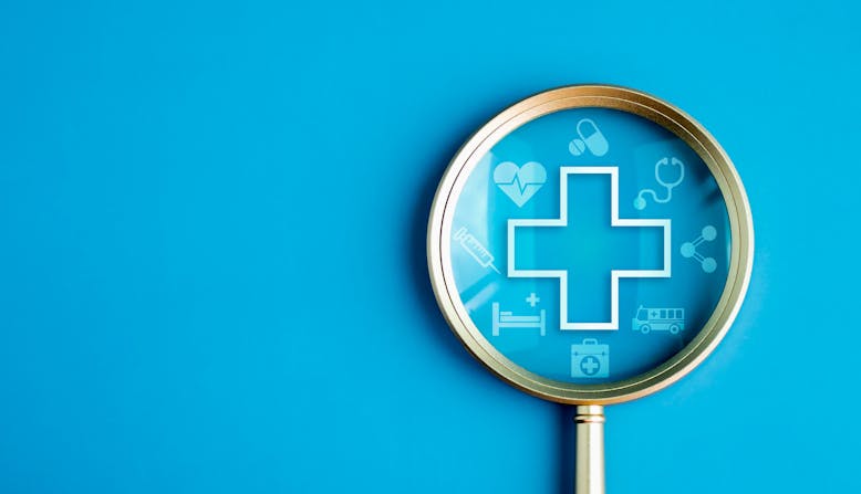 A magnifying glass and a health cross symbol