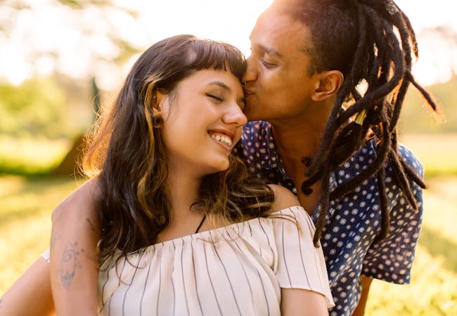 A couple embracing with a forehead kiss.