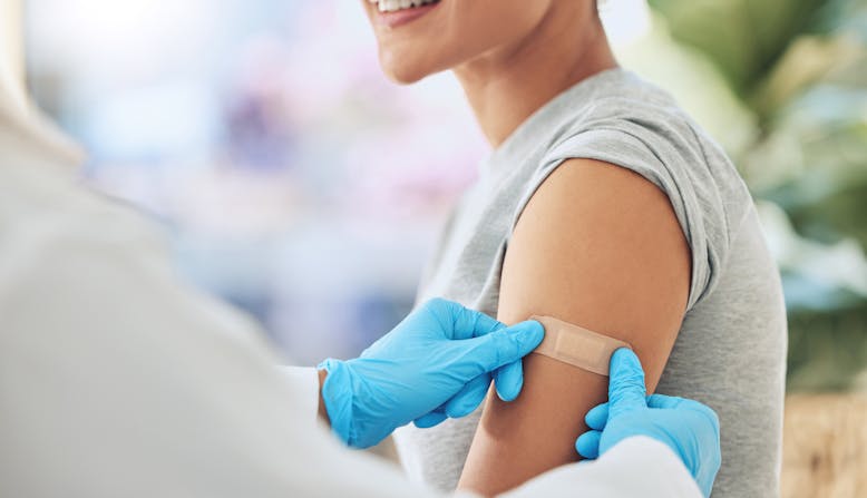 A woman gets a band aid after a vaccine.