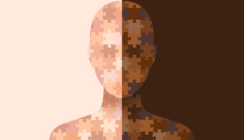 An illustration of a human figure made up of jigsaw puzzle pieces in the different colors of skin.