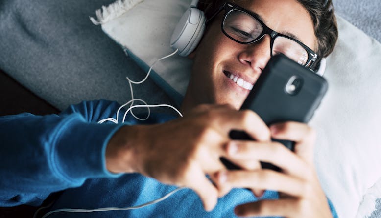 A young person listens to a podcast.