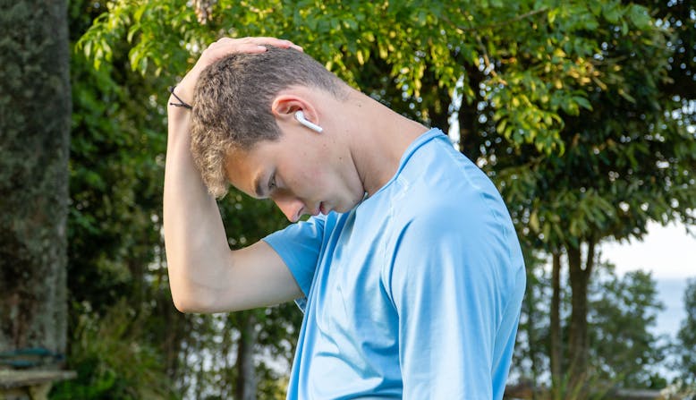 a young person listens to a podcast on ear pods