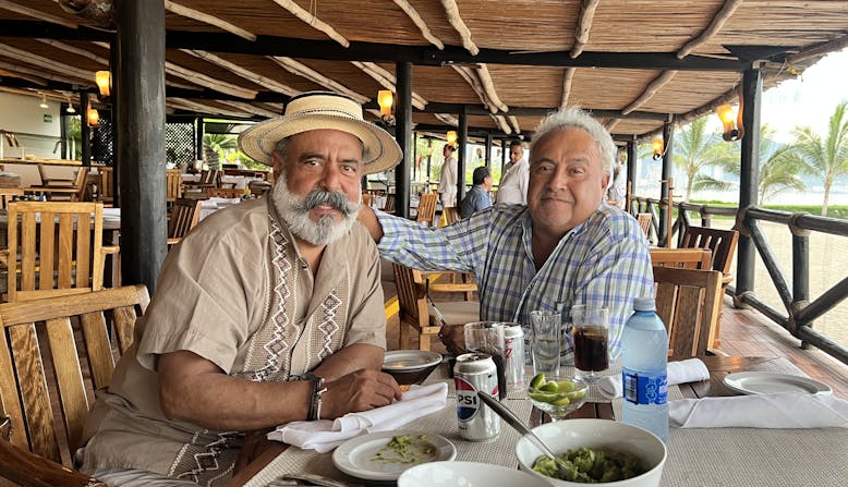 Humberto sits with a friend at a restaurant.