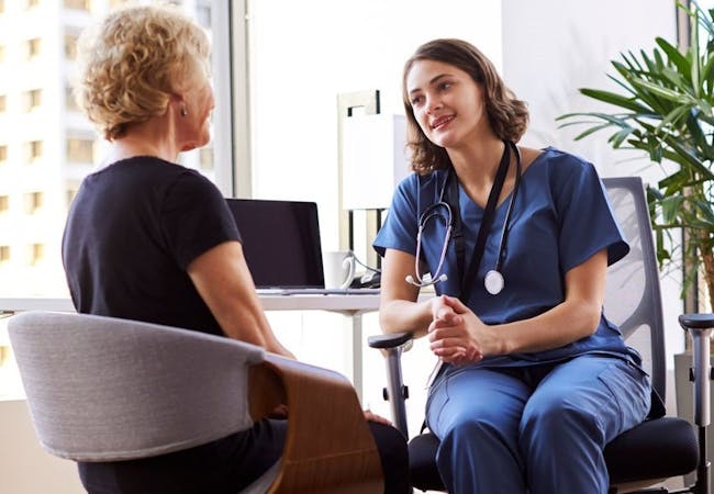 A doctor and patient discussing psoriatic disease in an office setting.