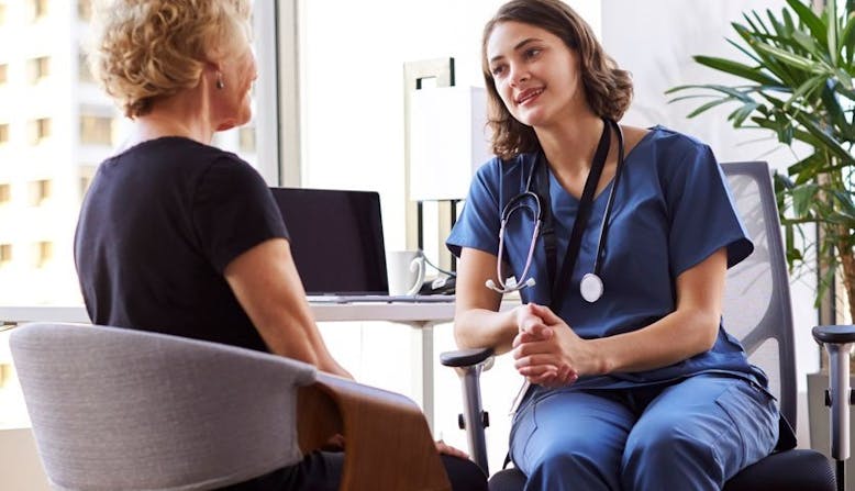 A doctor and patient discussing psoriatic disease in an office setting.